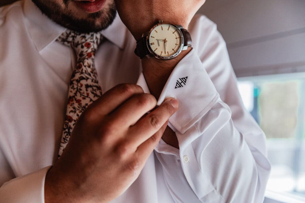 Groom adjusts watch during wedding prep at Hinckston Run Farm