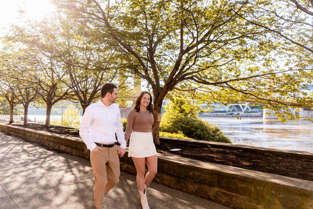 Couple shares romantic moments outdoors during a sunny Pittsburgh engagement photoshoot
