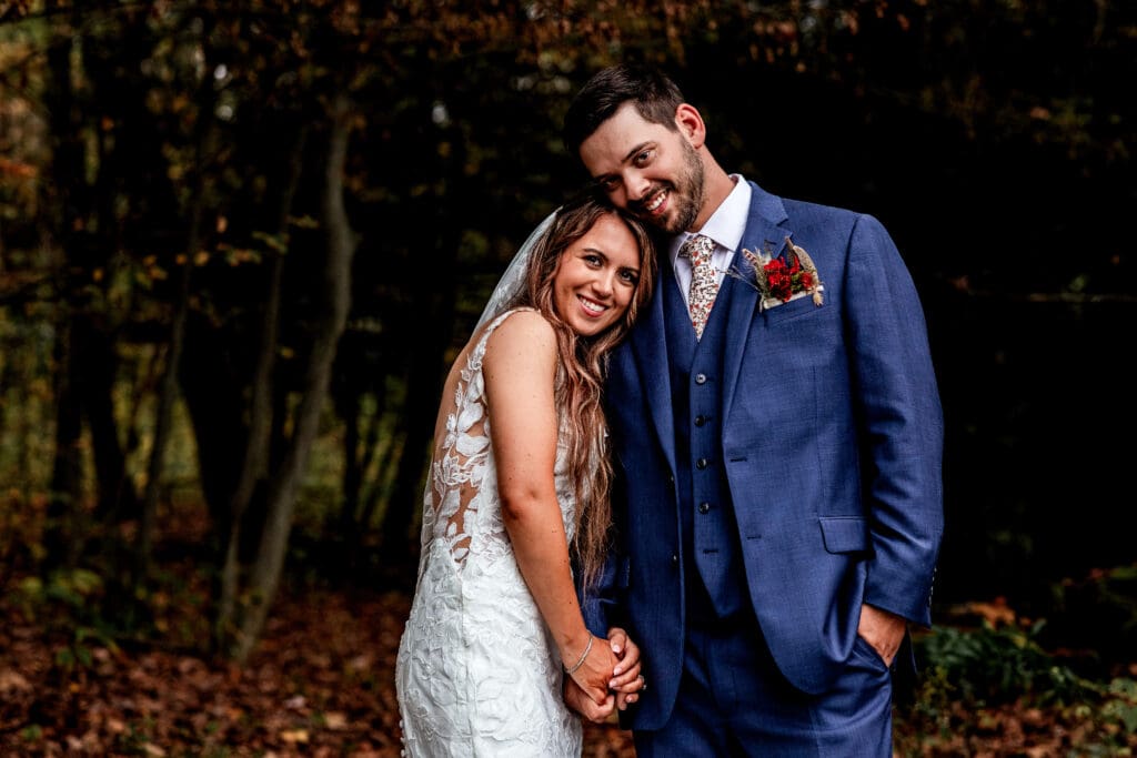 Newlyweds pose together in autumn forest at Hinckston Run Farm