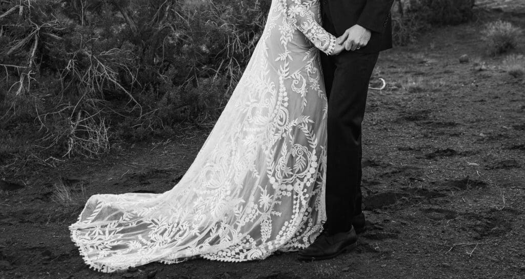 Close-up detail of an eloping couple holding hands during their intimate Moab elopement in the red rock desert.