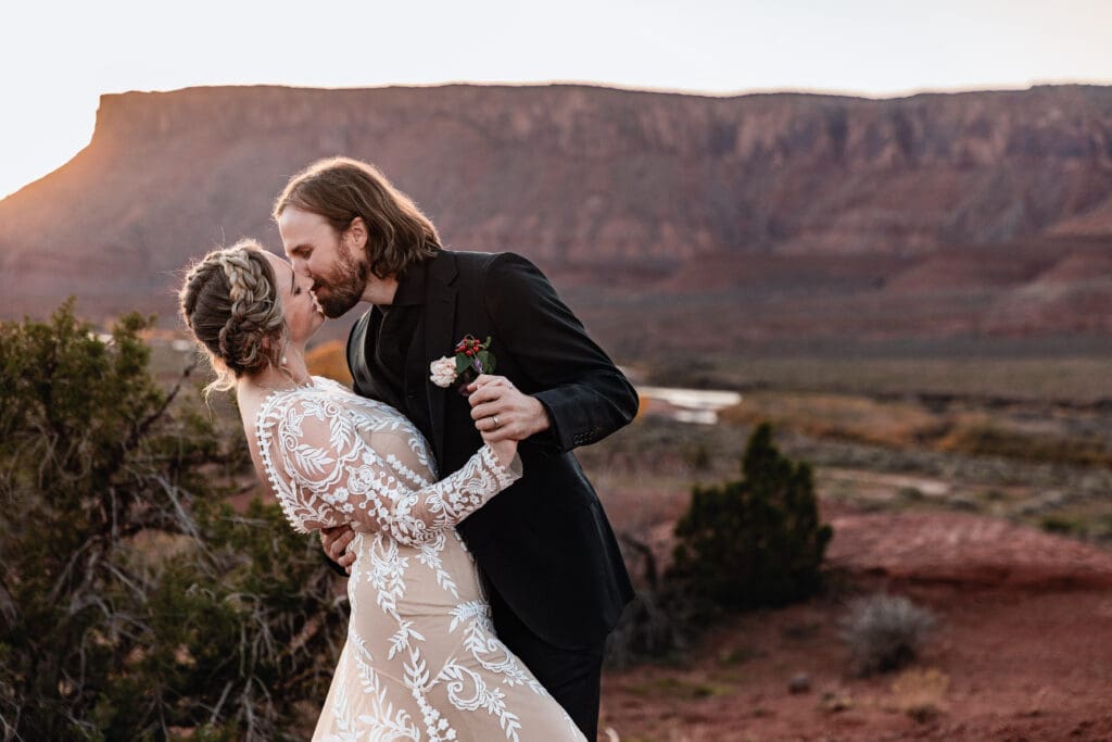 Close-up of a couple sharing a dip kiss at sunset during their romantic elopement in the Moab desert.