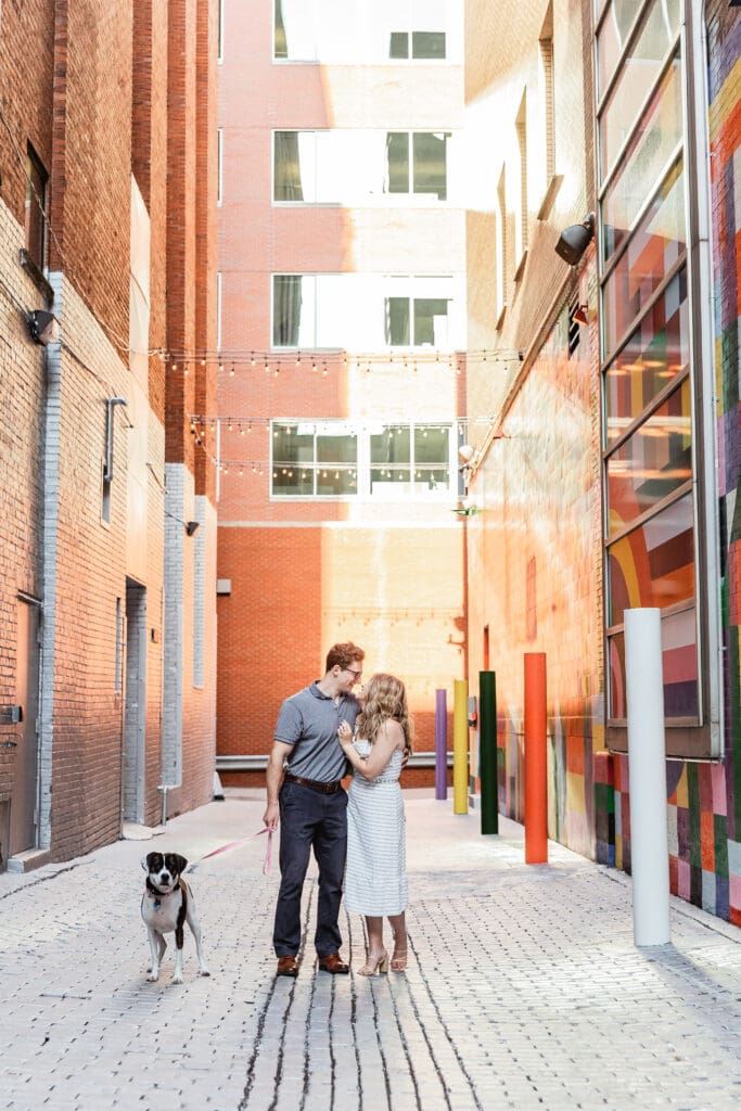 Couple poses with their dog in North Shore Pittsburgh during a city engagement photo session
