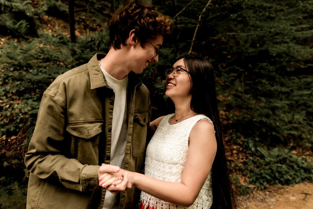 Couple shares a romantic moment on a forest trail beside a rushing stream at McConnells Mill State Park