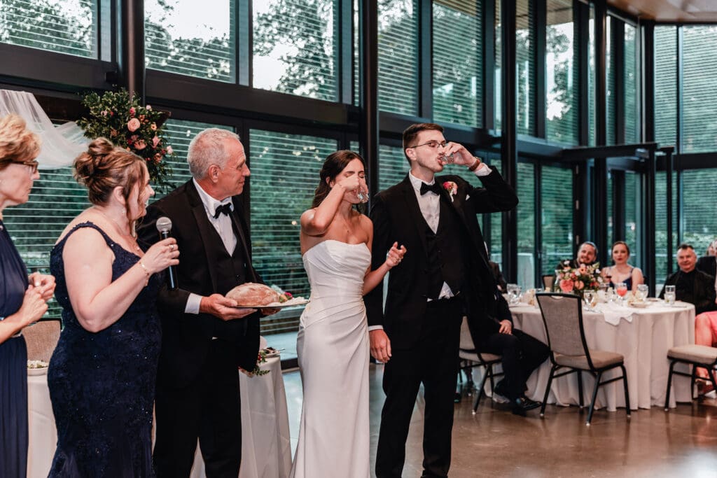 Bride and groom taking traditional Polish wedding shots together at the National Aviary reception
