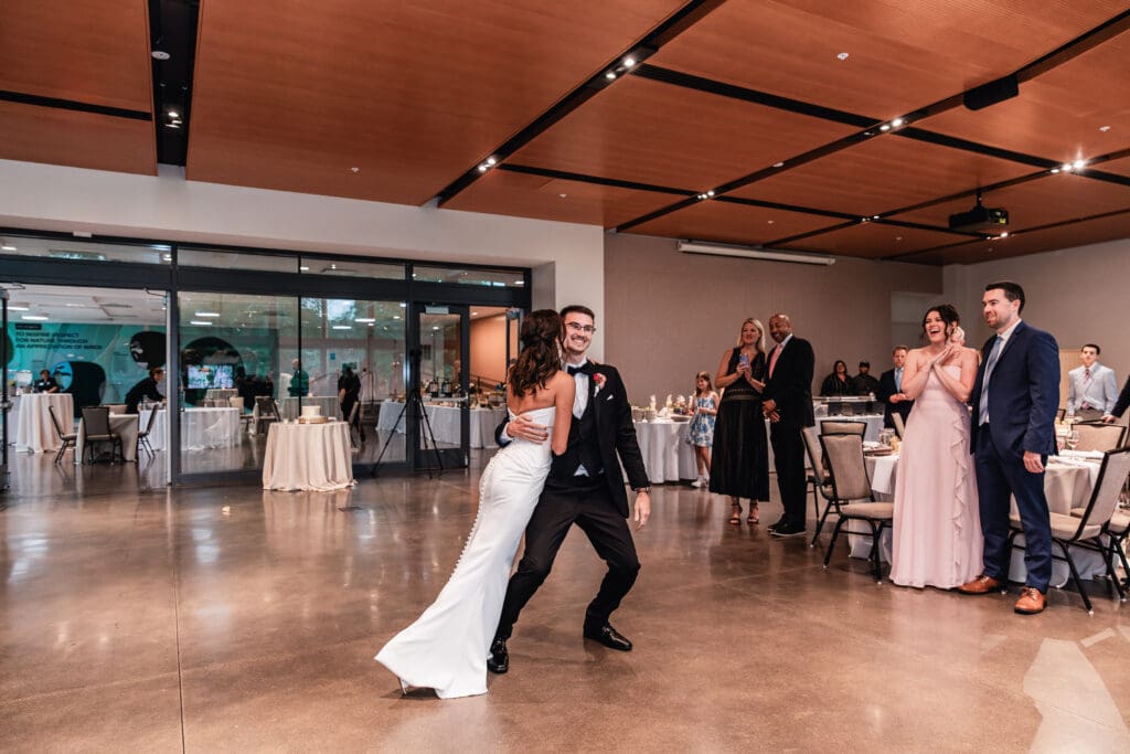 Bride kissing groom’s cheek during choreographed first dance at the National Aviary weddi