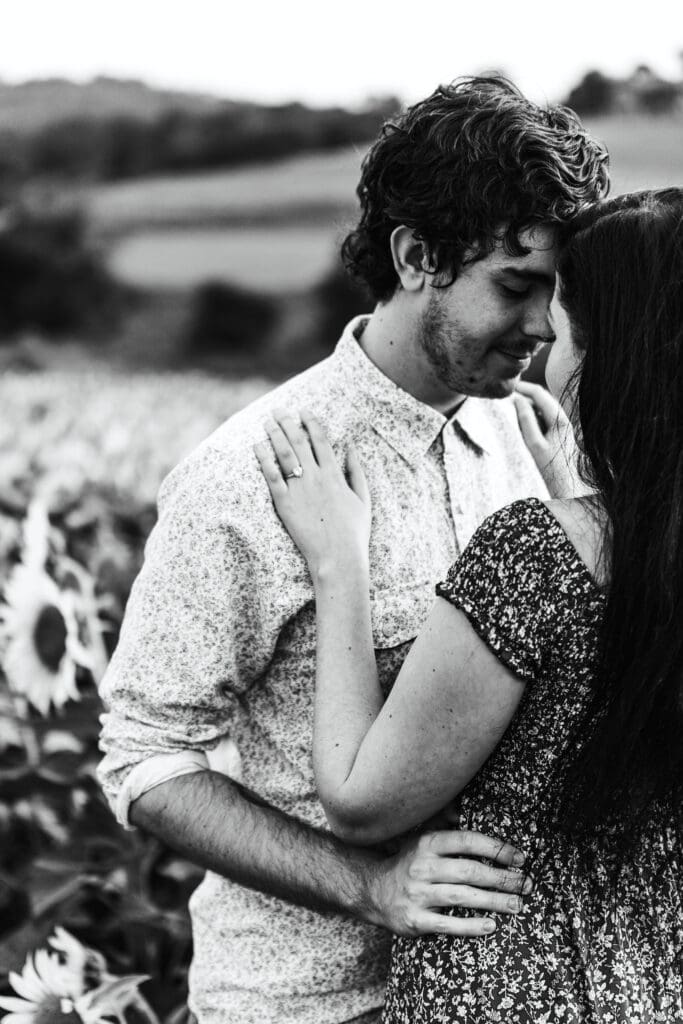 Engaged Pittsburgh couple embracing during golden hour in a vibrant sunflower field at Schwirian Sunflower Farm
