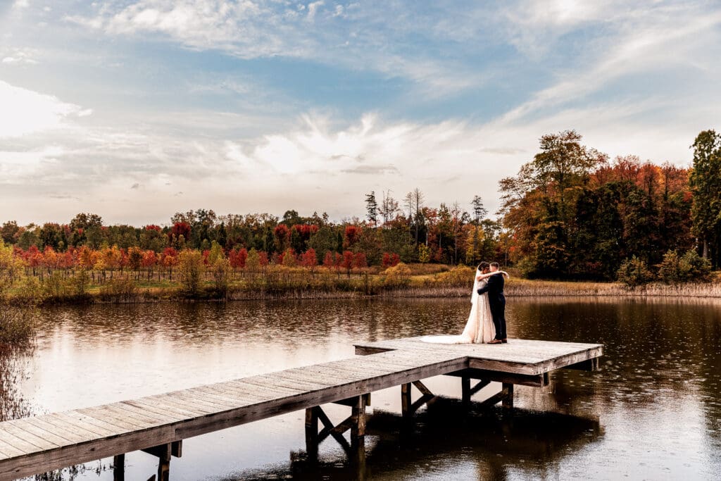 Pittsburgh bride and groom lean their foreheads together on dock at Pinehall at Eisler Farm