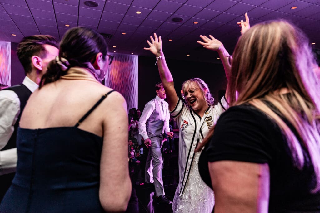 Wedding guests dancing together under purple lighting at The Fez reception