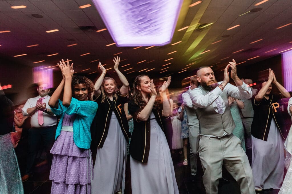Wedding guests dancing under purple and green lighting at The Fez