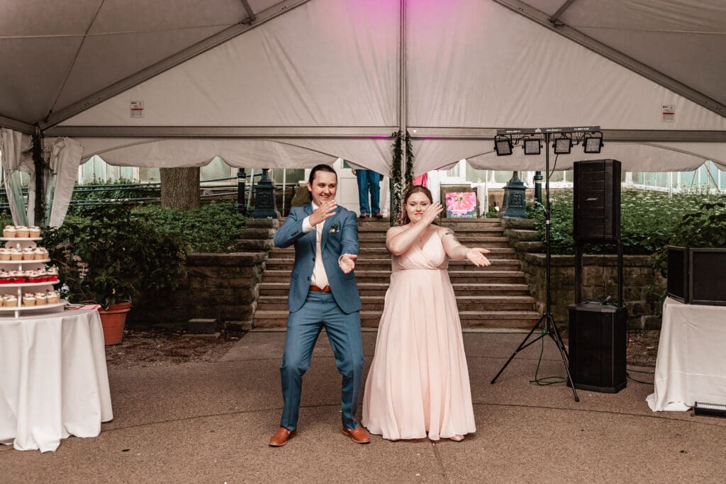 Wedding party dancing and laughing while entering the reception at Phipps Botanical Gardens in Pittsburgh