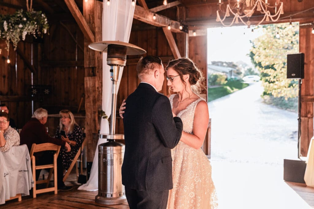 Bride and groom smiling while sharing first dance at Pinehall at Eisler Farm reception