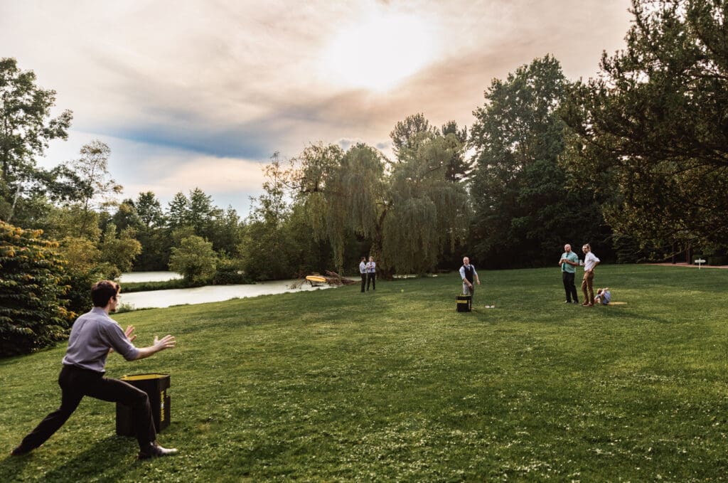 Wedding guests playing outdoor games on grassy field and enjoying activities at Succop Nature Park
