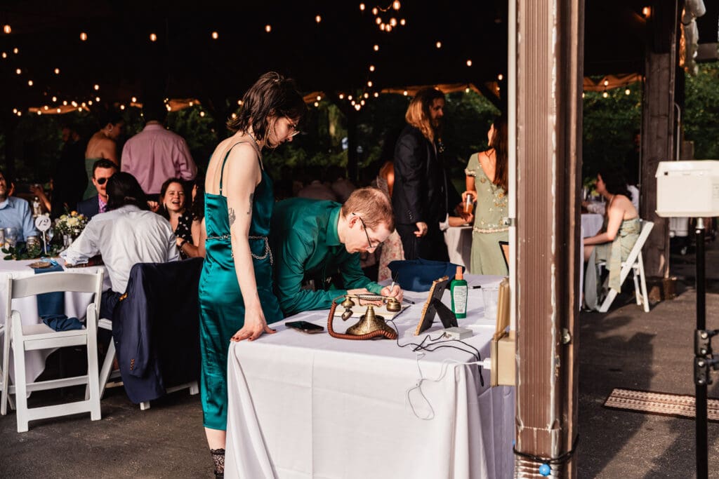 Wedding guests dining and mingling under twinkling string lights at outdoor reception at Succop Nature Park