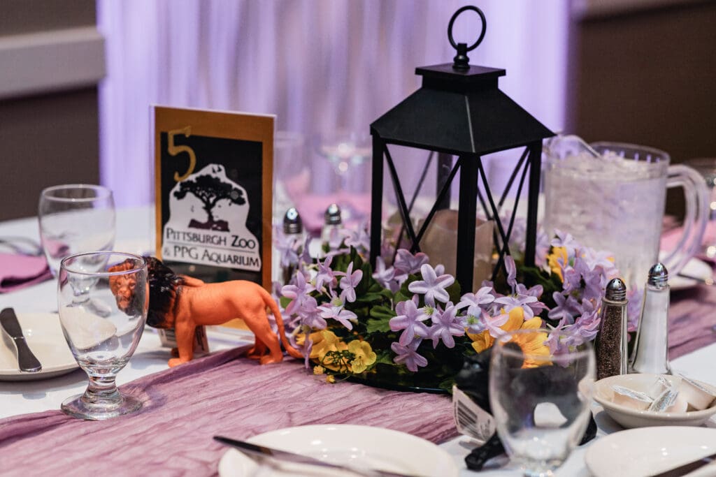 Wedding table setting with black lantern centerpiece, purple flowers, and framed photo at The Fez