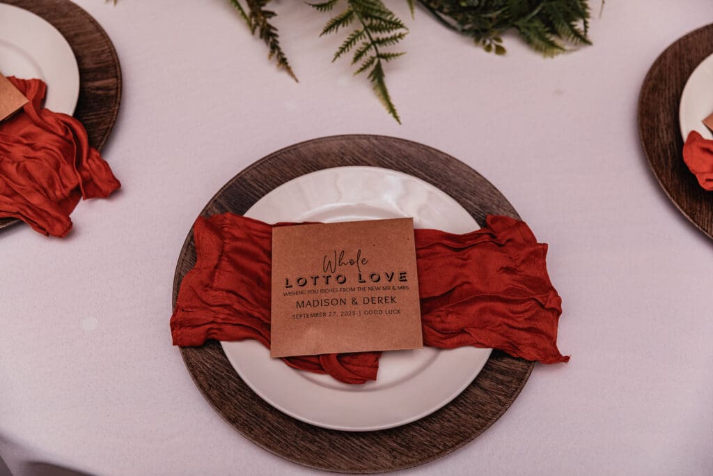 Rustic table setting with terracotta napkins, wooden charger plates, and fern accents at Hinckston Run Farm