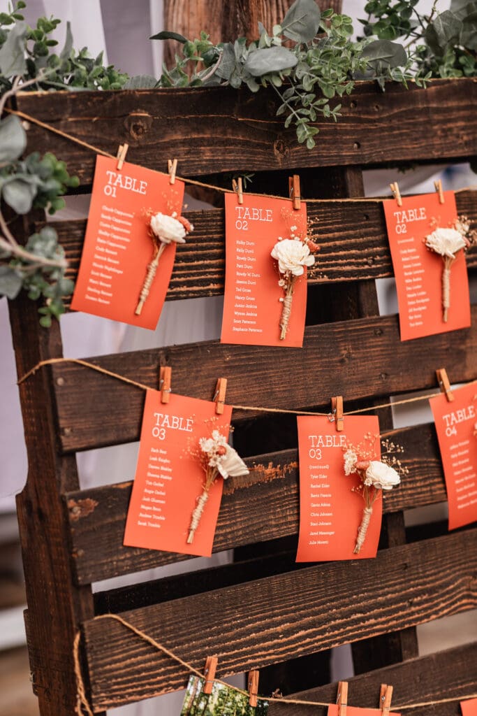 Wedding seating chart cards in warm orange tones at The Barn at Ever Thine in Butler County, PA