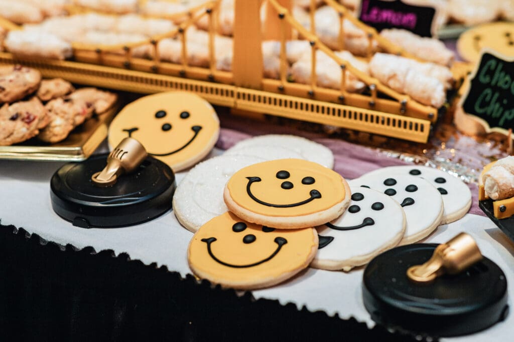 Cheerful smiley face cookies displayed at a wedding dessert table at The Fez