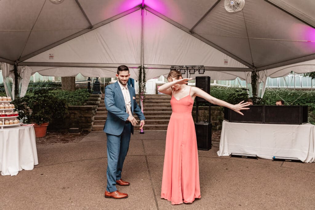 Bridesmaids and groomsmen striking fun poses for their grand entrance at a Pittsburgh Phipps Botanical Gardens wedding