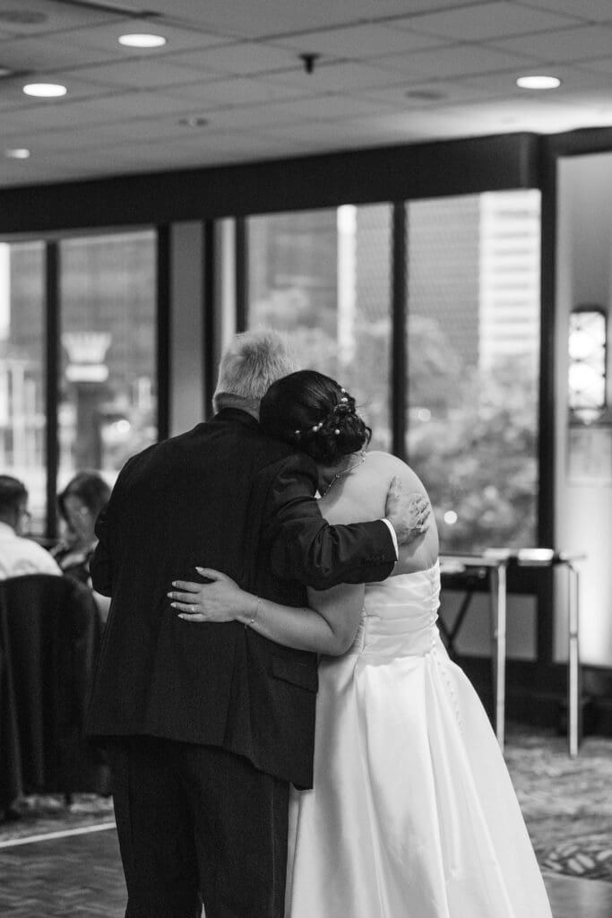 Black and white photo of bride hugging her father after their parent dance at Sheraton Station Square