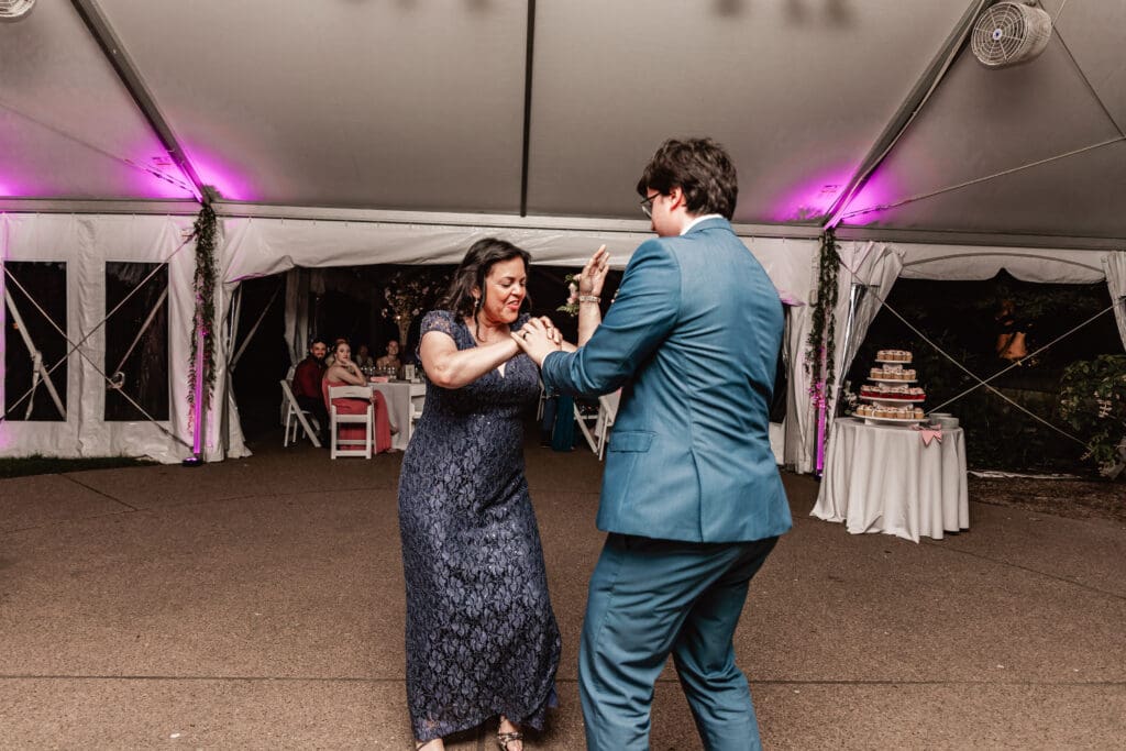Groom dancing and smiling with his mother during a Phipps Botanical Gardens wedding reception in Pittsburgh