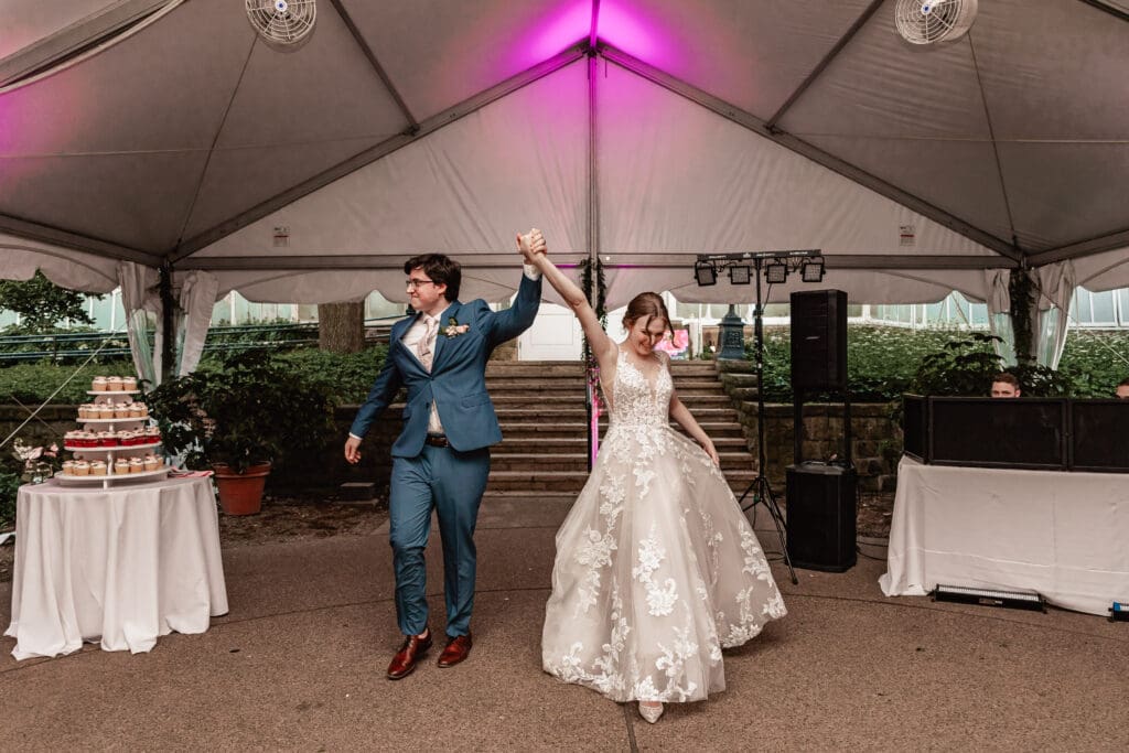 Pittsburgh bride and groom celebrating as they make their grand entrance at Phipps Botanical Gardens reception