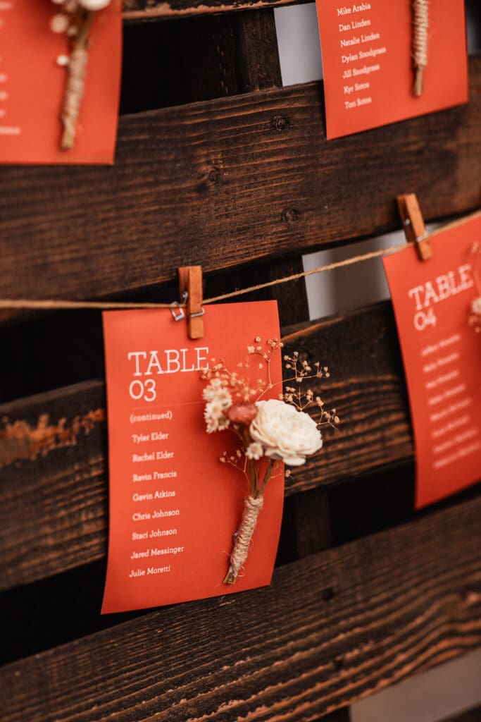 Close-up of orange seating chart cards displayed at The Barn at Ever Thine wedding in Butler County, PA