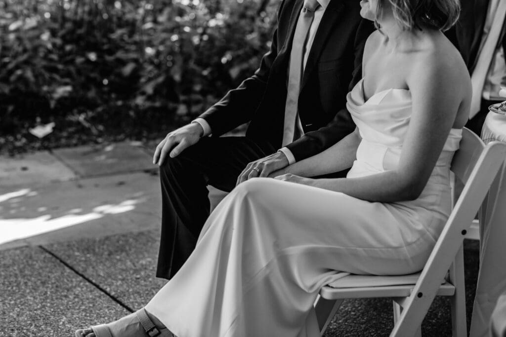Close-up of bride and groom holding hands during their microwedding reception at Schenley Park Welcome Center in Pittsburgh