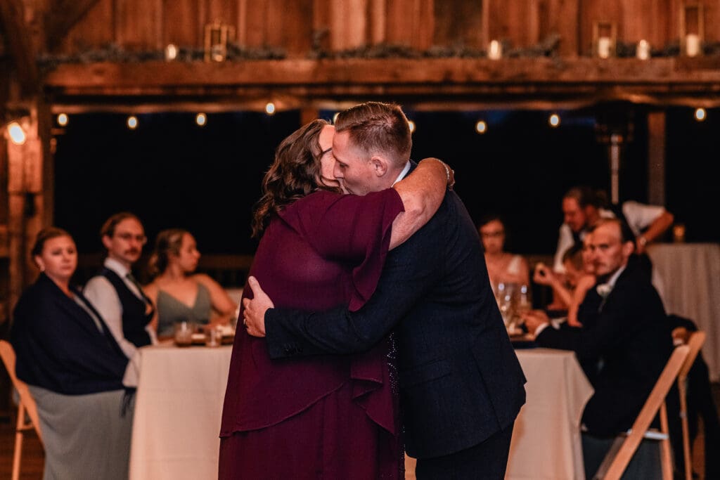 Mother of the groom and groom hug after their parent dance at Pinehall at Eisler Farm fall wedding reception