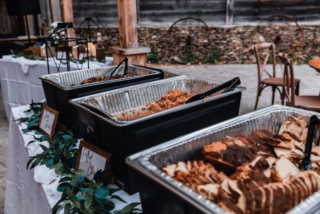 BBQ wedding catering displayed on wooden boards at a rustic Hinckston Run Farm wedding reception