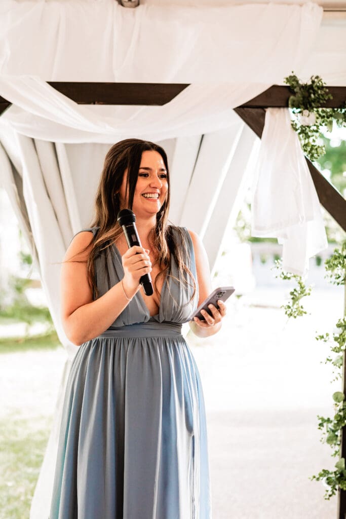 Bridesmaid smiling during her toast at a Schenley Park Welcome Center wedding reception in Oakland, PA
