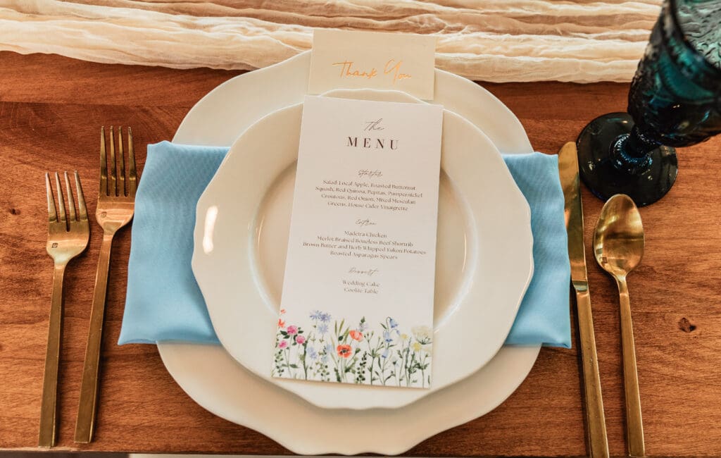 Close-up of reception place settings and printed menus at a Willowbrook wedding in Volant, Pennsylvania