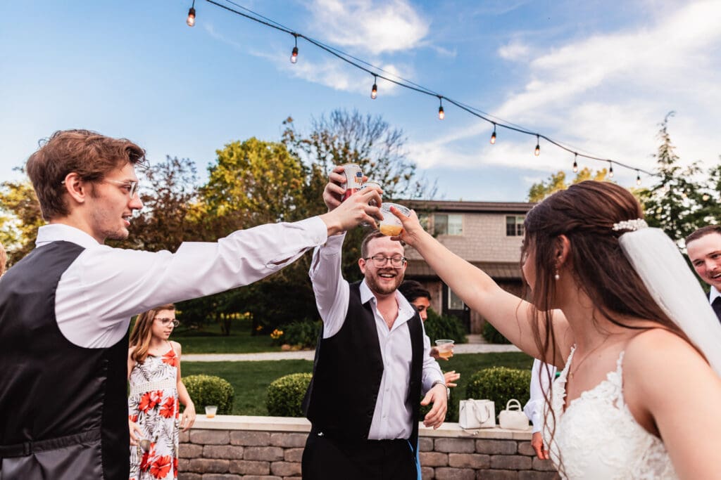 Guests celebrate with raised champagne glasses on the lawn at a Willowbrook wedding