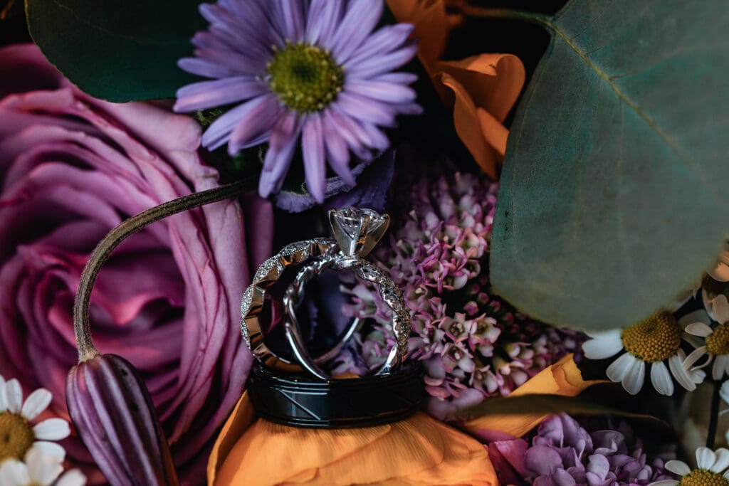 Wedding rings resting on purple floral arrangement at The Fez