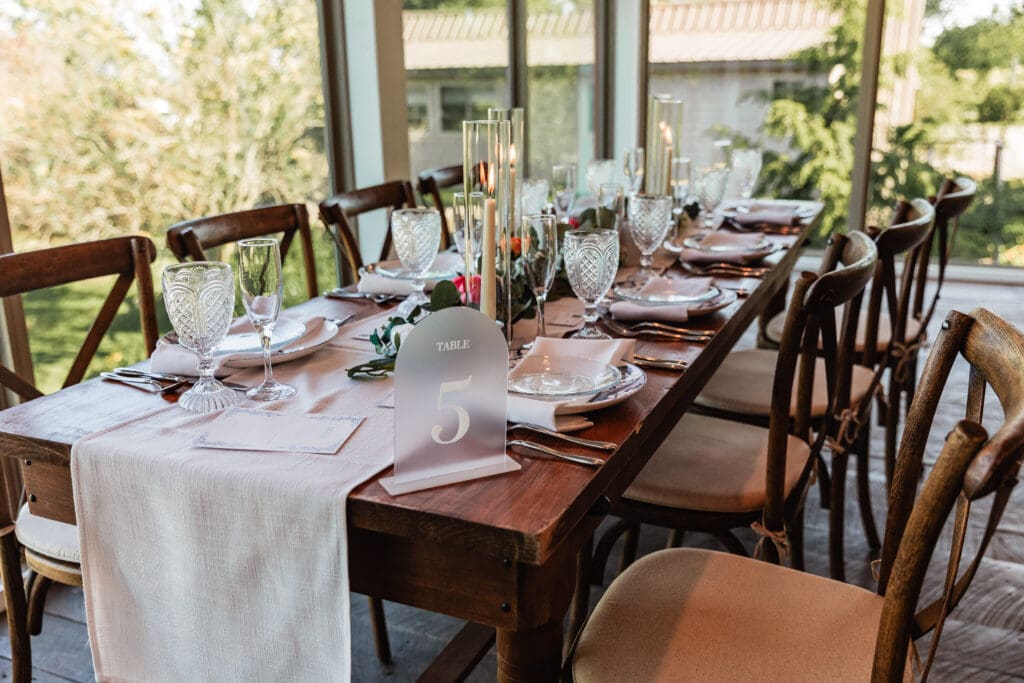 Reception room with white linens and wooden chairs prepared for a Willowbrook wedding