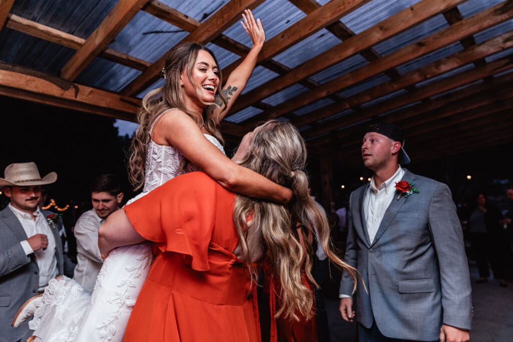 Wedding guests dancing under a rustic wooden pergola at outdoor Hinckston Run Farm reception