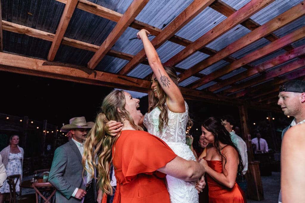 Wedding guests dancing on a dark dance floor illuminated by purple lighting at Hinckston Run Farm