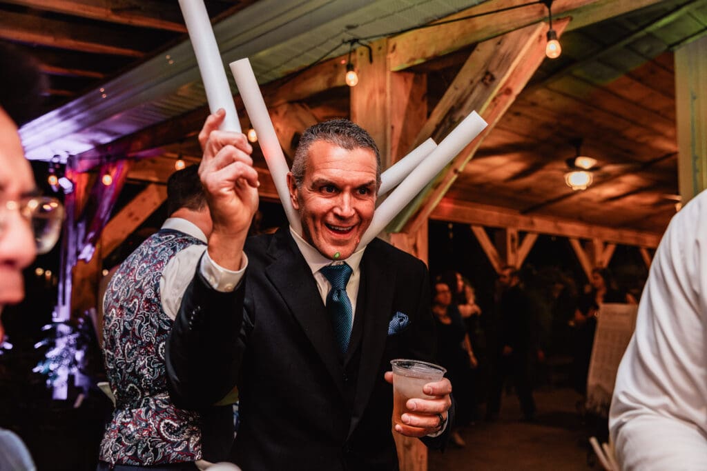 Guests dance together at an indoor wedding reception at Hinckston Run Farm