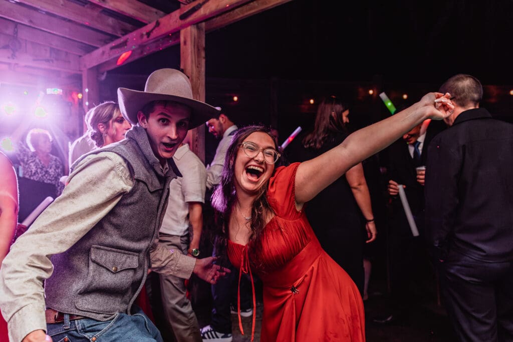 Wedding guests celebrate under purple lighting at Hinckston Run Farm