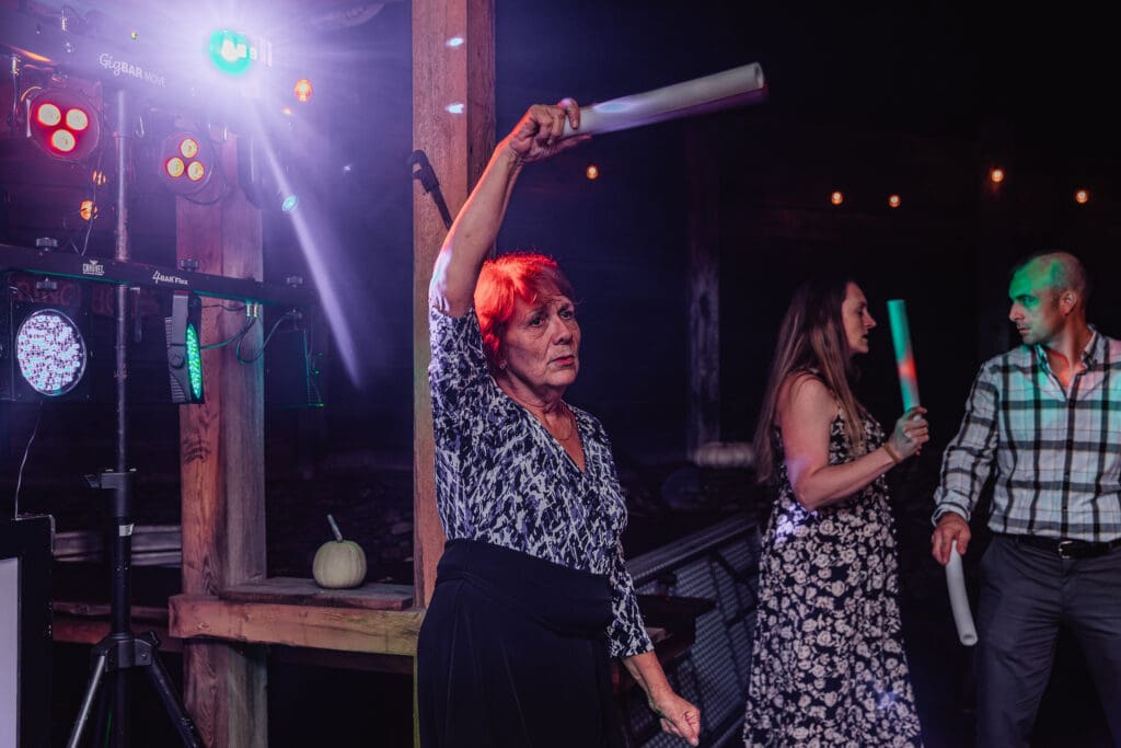 Guests dance with colorful lighting effects during Hinckston Run Farm reception