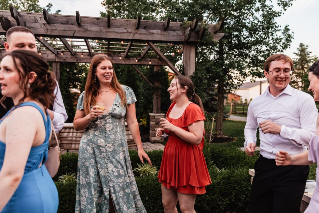 Guests enjoy a sunset wedding reception on a stone patio at Willowbrook