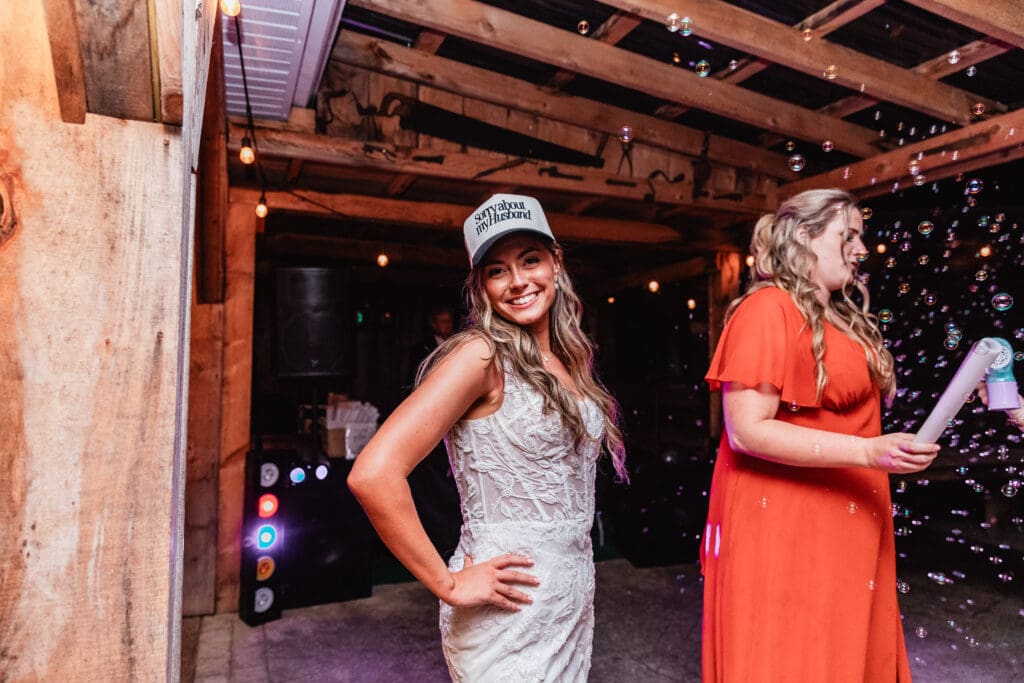 Wedding guests dancing in rustic wooden barn with warm lighting at Hinckston Run Farm