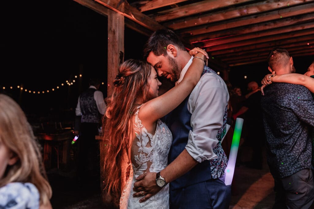 Wedding couple dance beneath wooden beams at Hinckston Run Farm