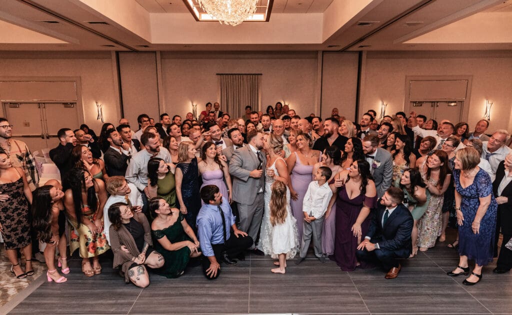 Bride and groom posing surrounded by wedding guests at Pittsburgh Airport Marriott reception