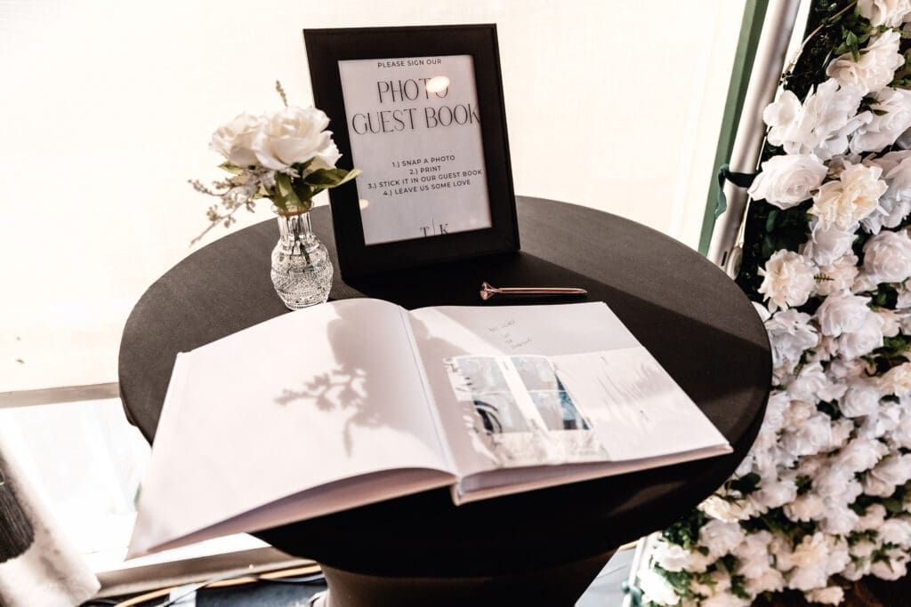 Floral shadows cast over a wedding guestbook at a Le Mont reception