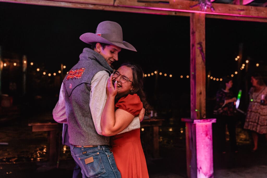 Couple dances beneath string lights at a rustic Hinckston Run Farm reception