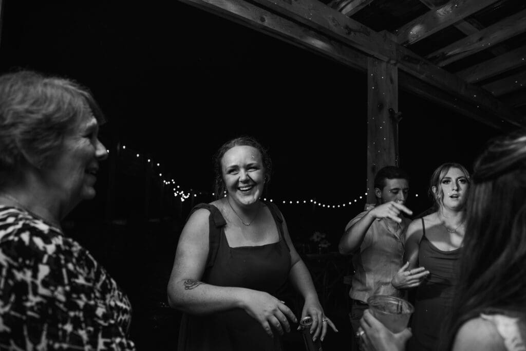 Wedding guests dance and celebrate on a dimly lit dance floor at Hinckston Run Farm