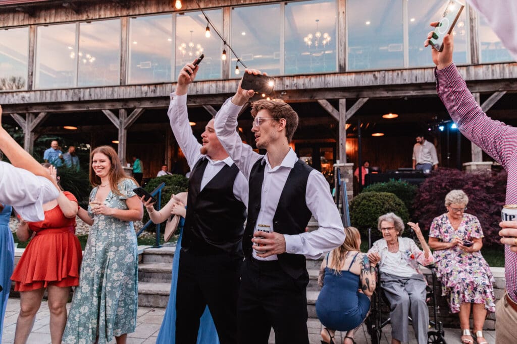 Wide view of guests gathered on a stone patio under string lights at Willowbrook