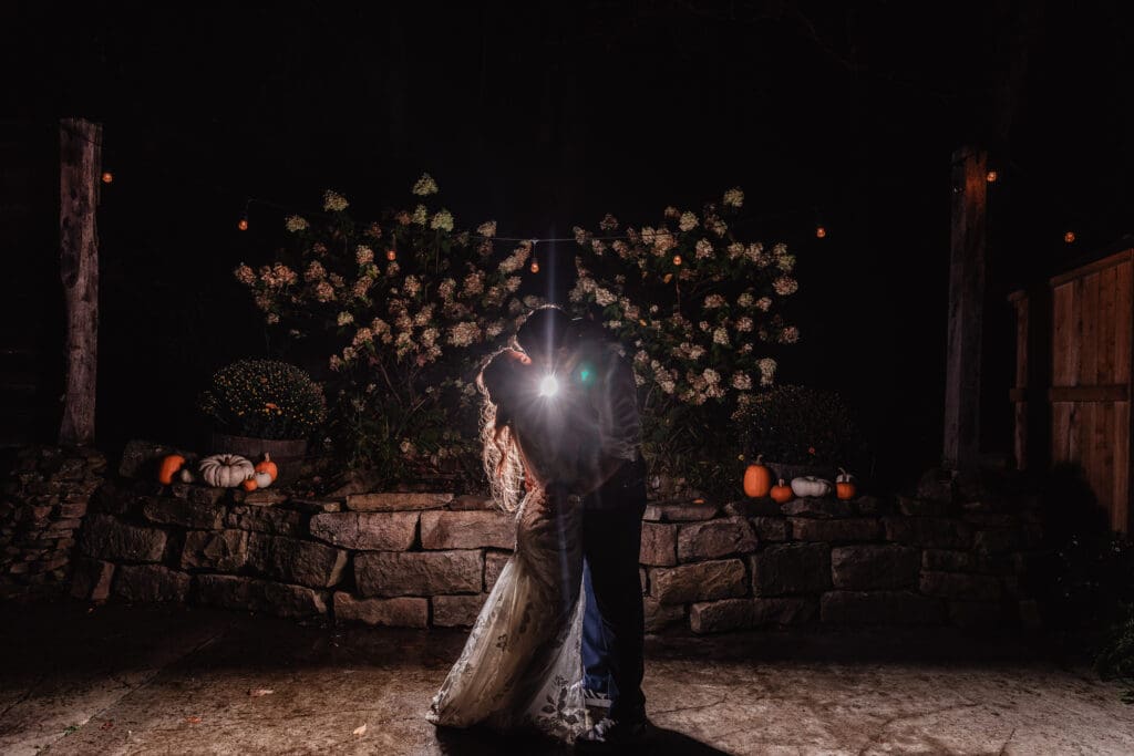 Backlit photo of wedding couple kissing at sunset at Hinckston Run Farm