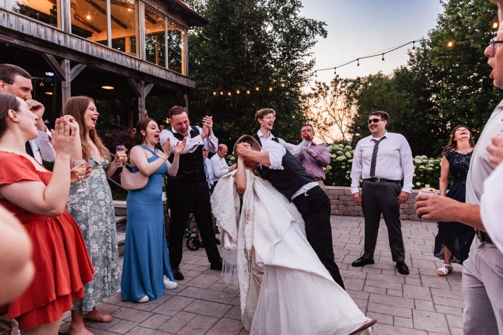 Wedding couple dances together on a stone patio at Willowbrook during their reception