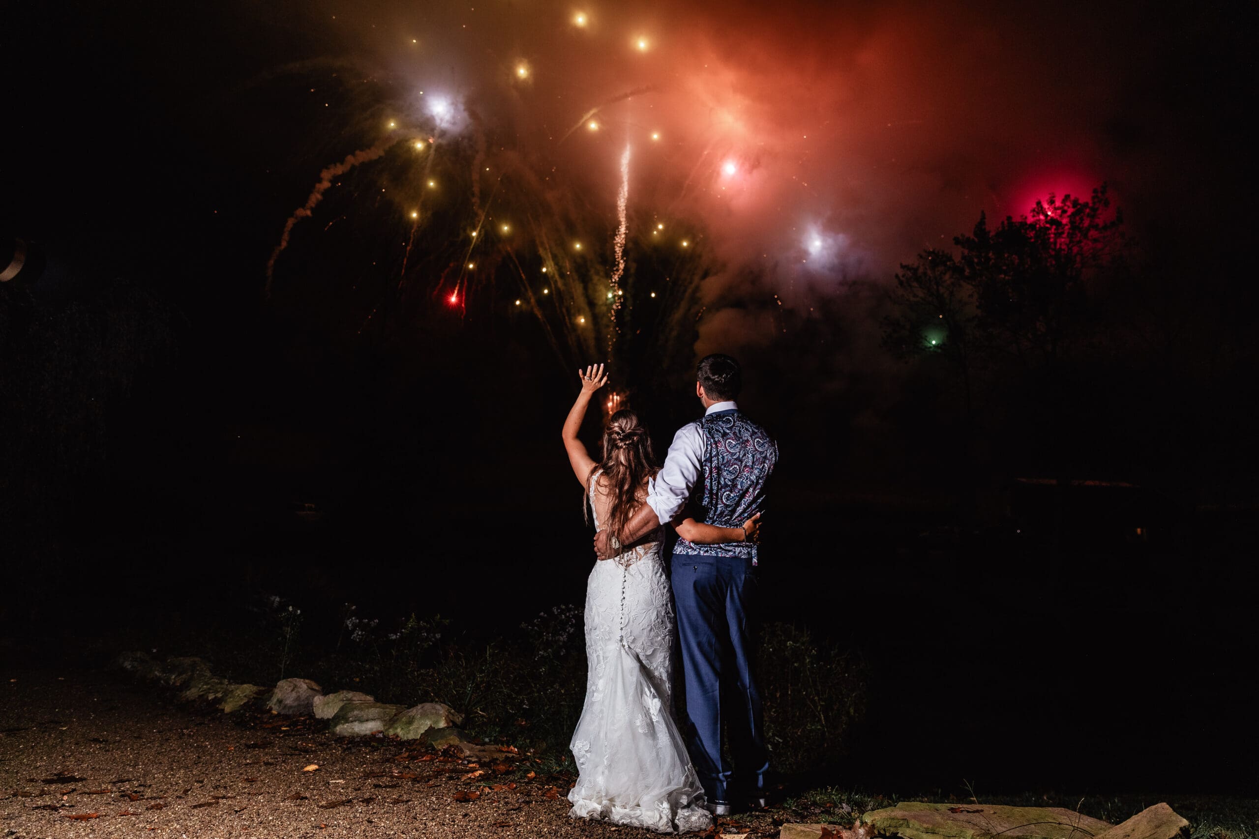Couple watches red fireworks light up the night sky during their Hinckston Run Farm wedding